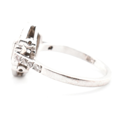 80 - An 18ct white gold and diamond Art Deco ring. The ring set with a central round cut diamond flanked ... 