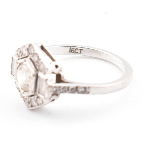 80 - An 18ct white gold and diamond Art Deco ring. The ring set with a central round cut diamond flanked ... 