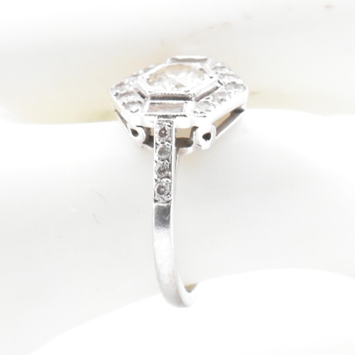 80 - An 18ct white gold and diamond Art Deco ring. The ring set with a central round cut diamond flanked ... 