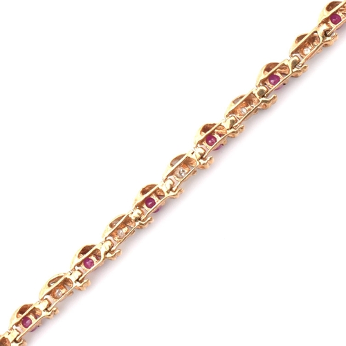 94 - A hallmarked 9ct gold, diamond and ruby line bracelet. The 9ct yellow gold bracelet having round cut... 