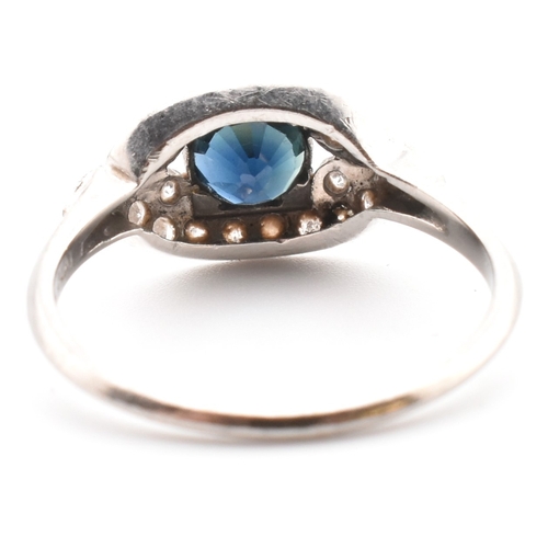 50a - Edwardian sapphire and diamond ring. The antique ring set with a round cut sapphire framed by a pier... 