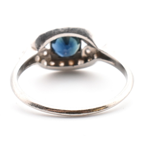 50a - Edwardian sapphire and diamond ring. The antique ring set with a round cut sapphire framed by a pier... 