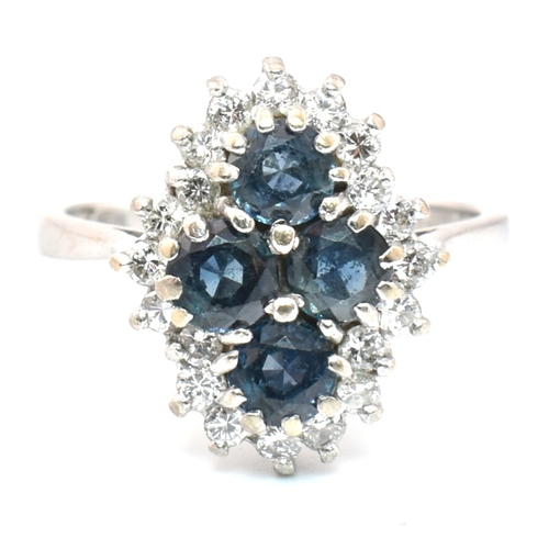 89a - A hallmarked 18ct gold sapphire and diamond cluster ring. The ring set with four round mixed cut sap... 