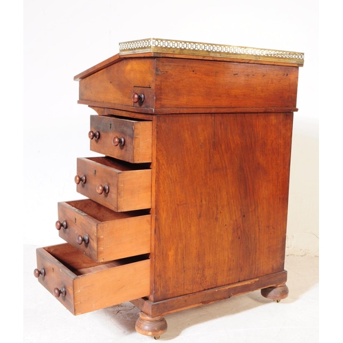 1006 - A 19th century Victorian era walnut Davenport writing desk. The desk having a gallery back over gree... 