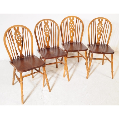 1009 - A collection of 20th century oak wheelback dining kitchen chairs. The chairs each raised on turned l... 