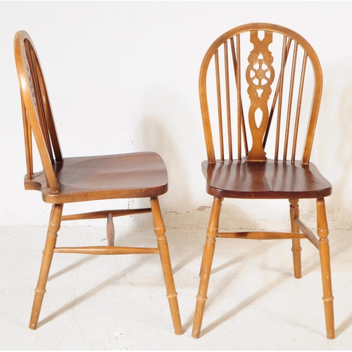 1009 - A collection of 20th century oak wheelback dining kitchen chairs. The chairs each raised on turned l... 