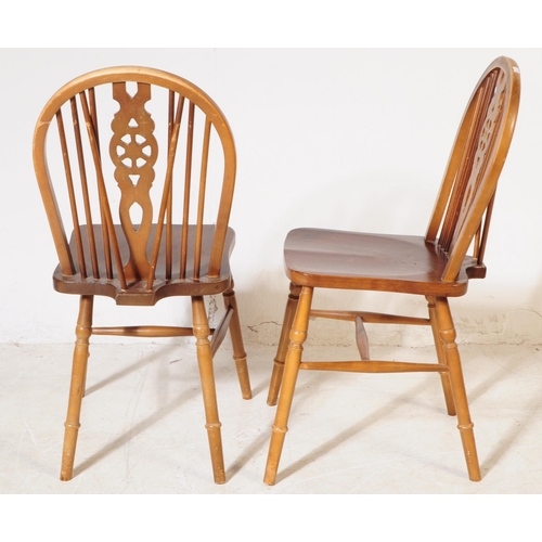 1009 - A collection of 20th century oak wheelback dining kitchen chairs. The chairs each raised on turned l... 