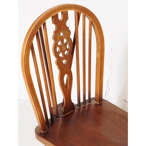 1009 - A collection of 20th century oak wheelback dining kitchen chairs. The chairs each raised on turned l... 