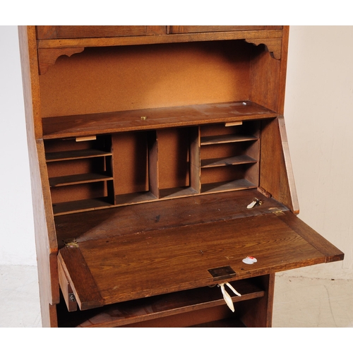 1012 - An early 20th century Arts and Crafts oak student bookcase bureau. The bureau having bookcase shelve... 