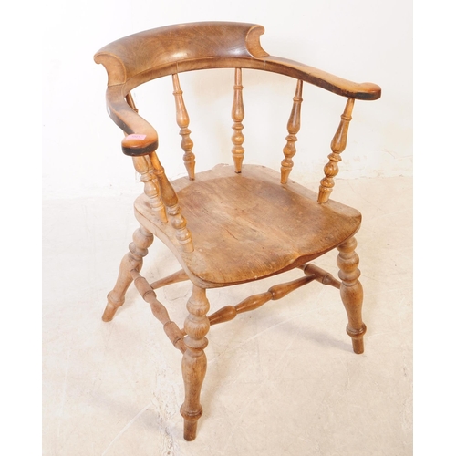 1021 - A 19th century Victorian beech and elm wood smokers bow armchair. The chair having a saddle seat rai... 