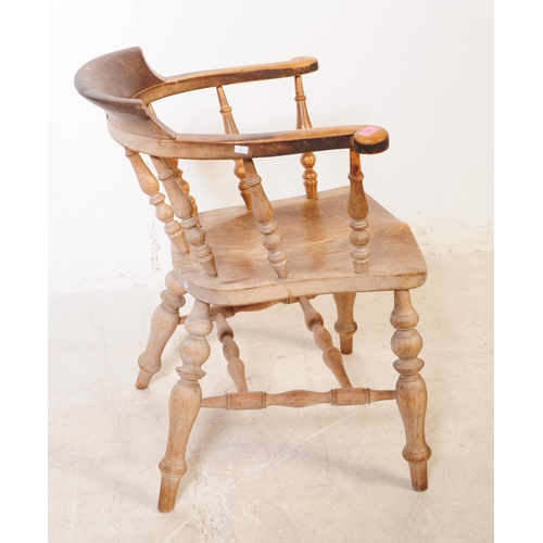 1021 - A 19th century Victorian beech and elm wood smokers bow armchair. The chair having a saddle seat rai... 