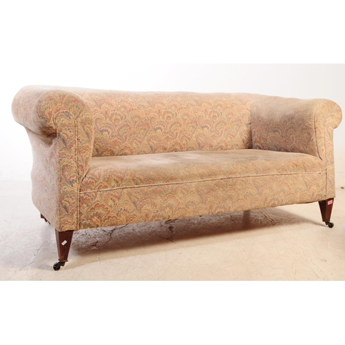 1023 - An early 20th century Edwardian chesterfield sofa and tub armchair. The sofa upholstered in polychro... 