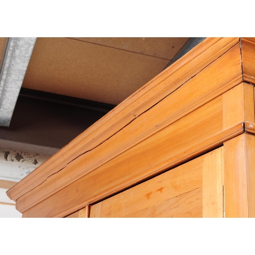 1025 - An early 20th century Edwardian walnut school cupboard. The school cupboard raised on a plinth base,... 