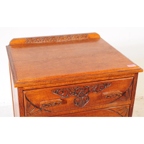 1040 - An early 20th Century circa 1930s arts and crafts oak four drawer chest of drawers having hand carve... 