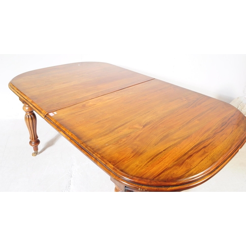 1044 - A Victorian revival mahogany wind out dining table. The table raised on shaped gadrooned supports ov... 