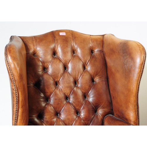 1052 - Chesterfield style - A 20th Century tan brown leather Chesterfield manner wingback armchair. Raised ... 