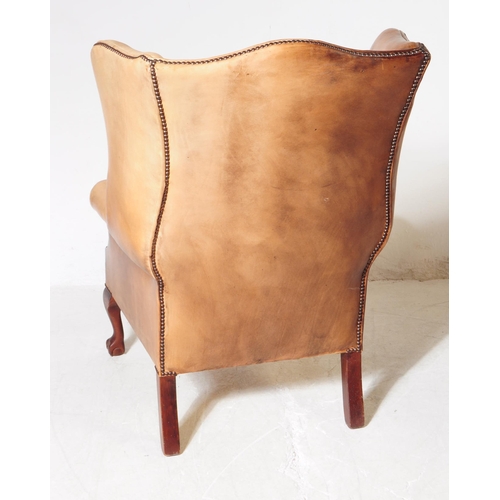 1052 - Chesterfield style - A 20th Century tan brown leather Chesterfield manner wingback armchair. Raised ... 