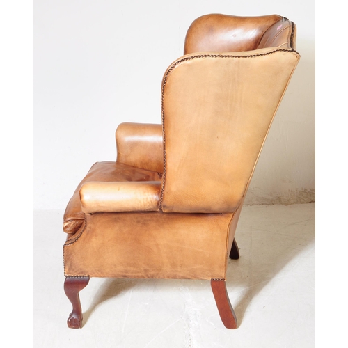 1052 - Chesterfield style - A 20th Century tan brown leather Chesterfield manner wingback armchair. Raised ... 