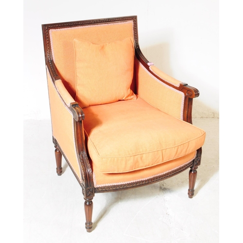 1055 - A pair of 20th century bergere French armchairs. The chairs having mahogany frames with moulded deta... 