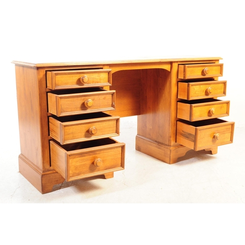 1073 - A 20th century hardwood twin pedestal desk having chamfered edge to top, raised over twin pedestals ... 