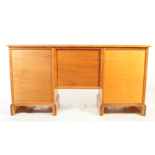 1073 - A 20th century hardwood twin pedestal desk having chamfered edge to top, raised over twin pedestals ... 