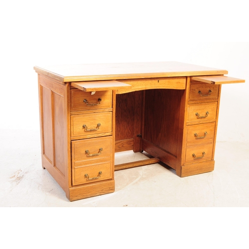 1075 - A 20th century oak twin pedestal desk. The desk having chamfered edge raised over twin pedestals, ea... 