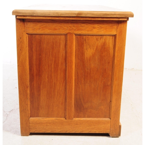 1075 - A 20th century oak twin pedestal desk. The desk having chamfered edge raised over twin pedestals, ea... 