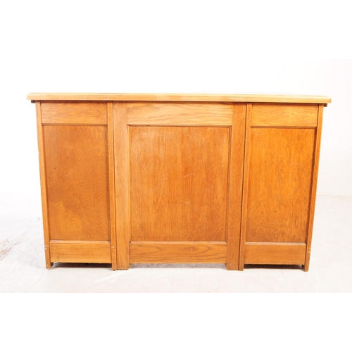 1075 - A 20th century oak twin pedestal desk. The desk having chamfered edge raised over twin pedestals, ea... 