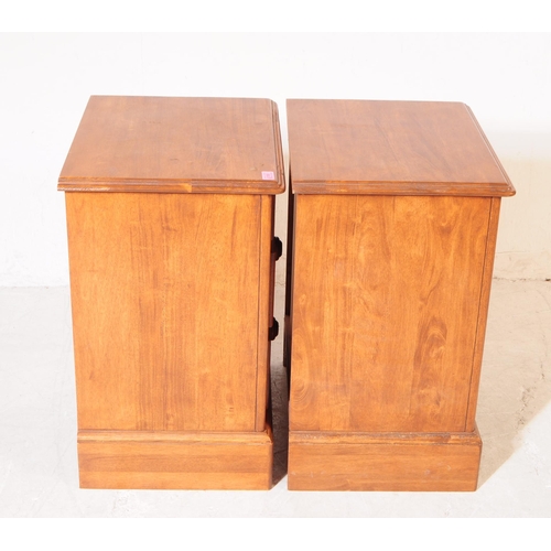 1077 - A pair of 20th century hardwood bedside pedestal chest of drawers. Each having chamfered top over a ... 