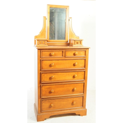 1081 - A 20th century hardwood dressing chest. The chest of drawers having mirror to top flanked by trinket... 