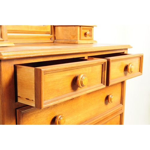 1081 - A 20th century hardwood dressing chest. The chest of drawers having mirror to top flanked by trinket... 