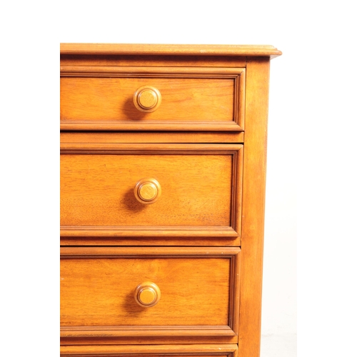 1081 - A 20th century hardwood dressing chest. The chest of drawers having mirror to top flanked by trinket... 