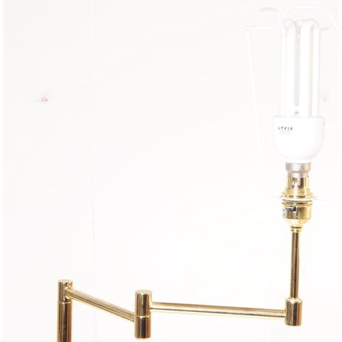 1087 - Two 20th century brass adjustable swing arm floor standing standard lamps. The lamps each raised on ... 