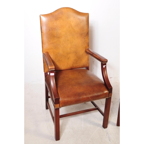 1106 - A pair of 20th century George III style leather and mahogany Gainsborough chairs having leather upho... 