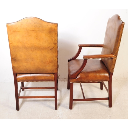 1106 - A pair of 20th century George III style leather and mahogany Gainsborough chairs having leather upho... 