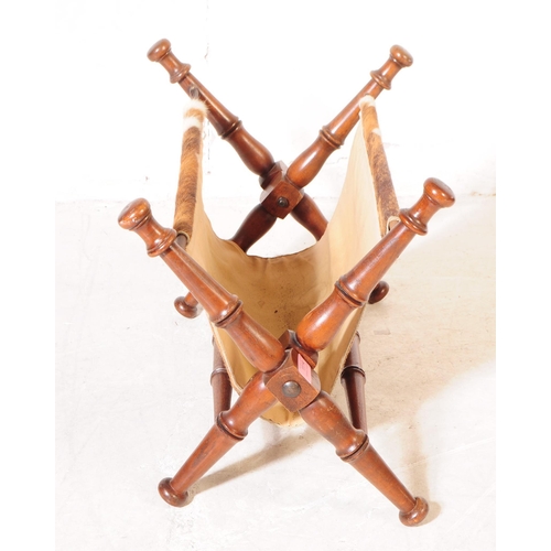 1114 - A mid 20th century mahogany frame magazine rack. The magazine rack having turned wood supports with ... 