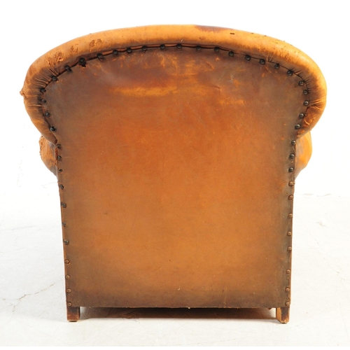 1117 - An early 20th century Howards manner club armchair. The chair having shaped backrest over deep seat ... 