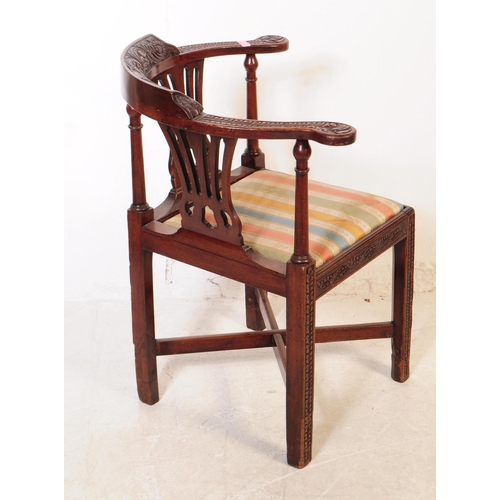 1120 - A 19th century George III carved mahogany corner armchair. The chair raised on carved block legs, ha... 