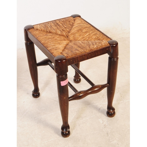 1122 - A pair of early 20th century oak wood rush seat stools. The stools raised on tapered rounded legs ov... 