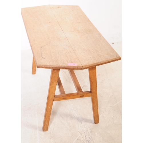 1123 - An early 20th century oak wood trestle leg side table. The table raised on tapered trestle style leg... 