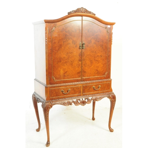 1125 - A 20th century walnut cocktail cabinet. The cabinet raised on carved cabriole legs, having a pair of... 