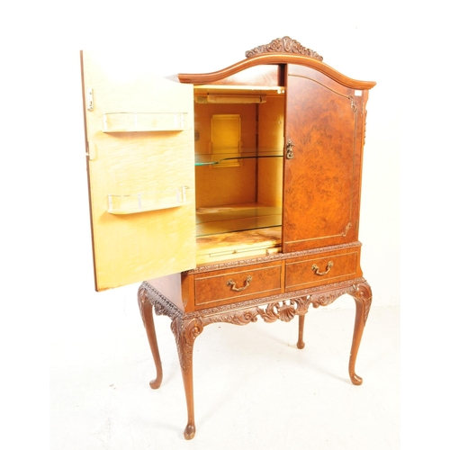 1125 - A 20th century walnut cocktail cabinet. The cabinet raised on carved cabriole legs, having a pair of... 