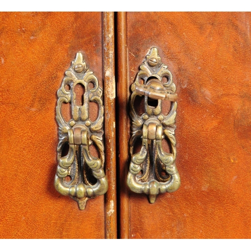 1125 - A 20th century walnut cocktail cabinet. The cabinet raised on carved cabriole legs, having a pair of... 