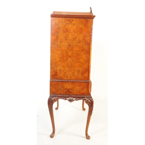 1125 - A 20th century walnut cocktail cabinet. The cabinet raised on carved cabriole legs, having a pair of... 