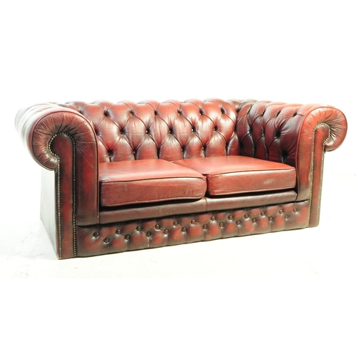 1126 - A 20th century Chesterfield two seater sofa settee. The sofa in oxblood red leather, featuring a but... 