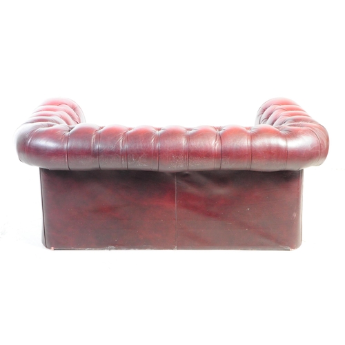 1126 - A 20th century Chesterfield two seater sofa settee. The sofa in oxblood red leather, featuring a but... 