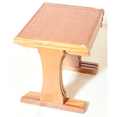 563 - G-Plan - A mid 20th century G-Plan teak and copper nest of side tables. The nest of tables raised on... 