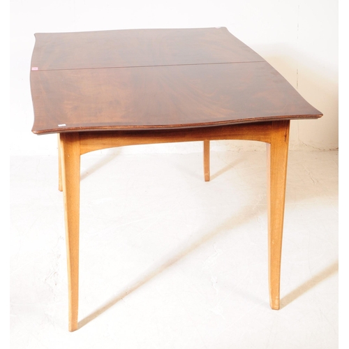 568 - A mid 20th century walnut veneer extending dining table. The table having armorial shaped top, raise... 