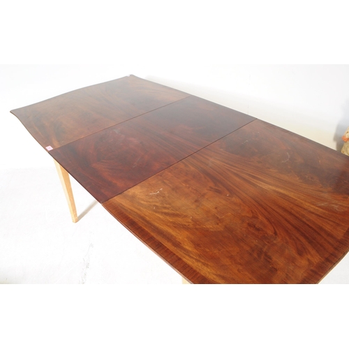 568 - A mid 20th century walnut veneer extending dining table. The table having armorial shaped top, raise... 