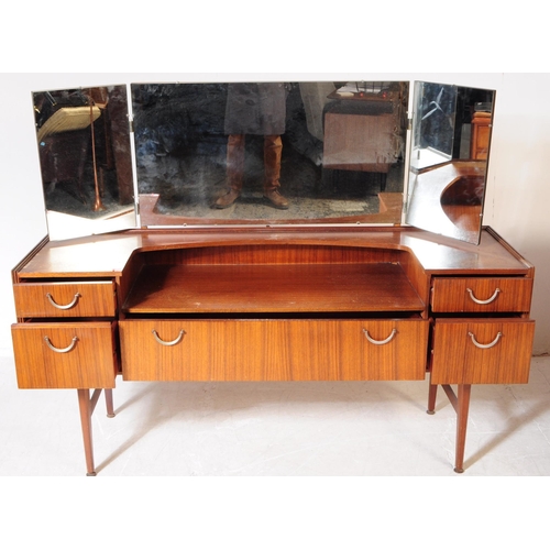 587 - British Modern Design - A mid 20th century teak veneer dressing table. The dresser raised on tapered... 